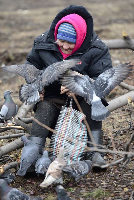 Місцеві жителі отримують гарячі обіди від волонтерів і навіть діляться з птахами. Фото: AFP