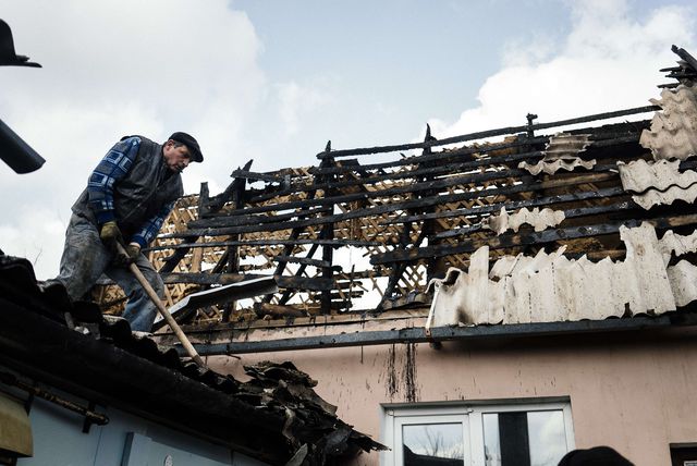 Донеччани розбирають завали і згарища на дахах будинків. Фото: AFP