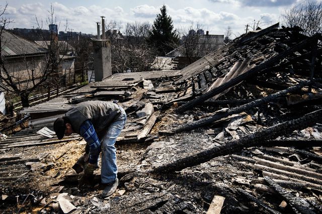 Донеччани розбирають завали і згарища на дахах будинків. Фото: AFP