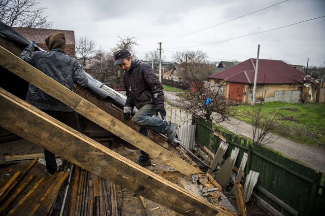 Місцеві жителі відновлюють зруйновані оселі в селищі Жабунькі під Донецьким аеропортом. Фото: AFP