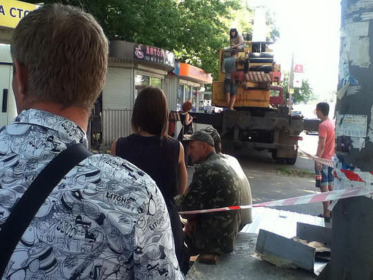 Во время попытки демонтажа незаконно установленного МАФа владелица одного из них вылезла на автокран. Фото: everyday.in.ua