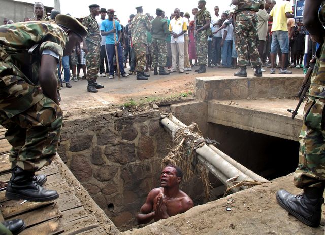 У Бурунді чоловік просить допомоги у військових, після того, як сховався від лінчування. Фото: AFP