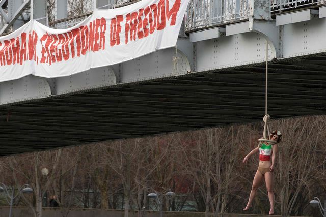 Активистки Femen встретили прибывшего в Париж иранского президента имитацией повешения. Фото: AFP