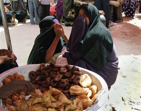 Город Могадишу. Женщины продают традиционную в Сомали самсу. Рынки страны переполнены, мусульмане закупают впрок выпечку и фрукты. Хотя кушать в светлое время суток нельзя, ночью запрет на употребление пищи снимается, многие несут снедь в мечети, где делят трапезу с близкими. Фото АР