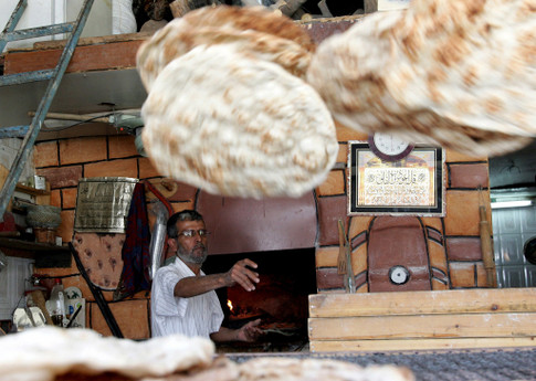 Дженин, Западный берег реки Иордан. Палестинец студит лепешки – одно из традиционных здесь блюд. Перед рамаданом многие мусульмане закупают впрок местную выпечку и фрукты. Фото AFP 