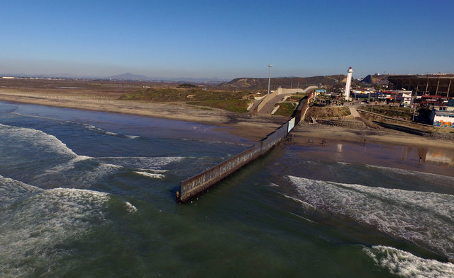 Металлическая стена, разделяющая США и Мексику, упирается в океан. Фото: AFP