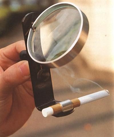 ЗАЖИГАЛКА<br />
Для экономии спичек, можно использовать увеличительное стекло с зажимом. В зажим вставляется сигарета и с помощью солнечного луча, который проходит через стекло, сигарета начинает тлеть.